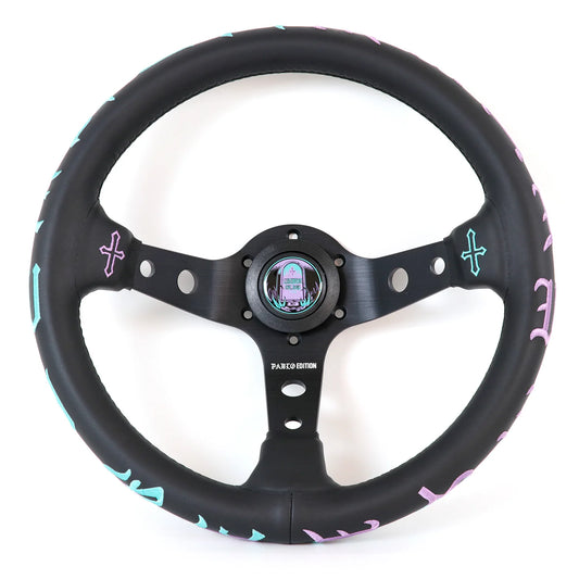 A black leather-wrapped car steering wheel with a matching black three-spoke center, featuring pastel pink and light blue decorative accents along the rim and a colorful iridescent center cap, shown on a white background.