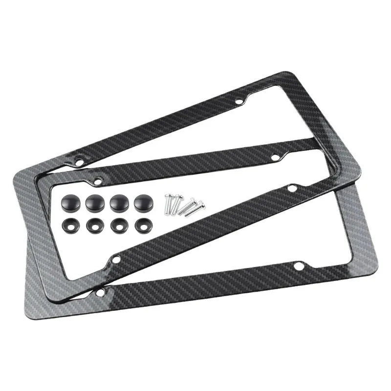 Two carbon fiber number plate frames with mounting hardware on a white background