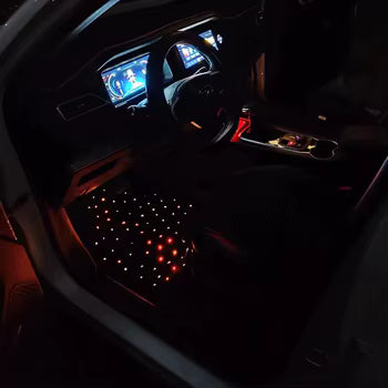 Car interior with illuminated dashboard and steering wheel in a dark setting