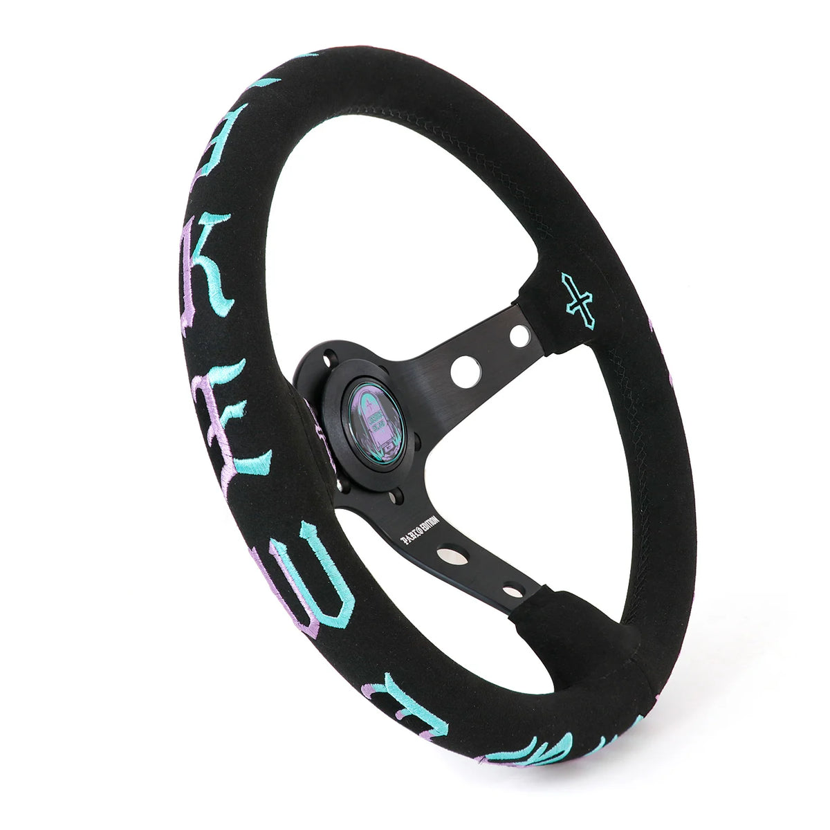 A black multi-spoke steering wheel with a black suede-like rim cover featuring light blue and purple gothic lettering, shown on a white background.