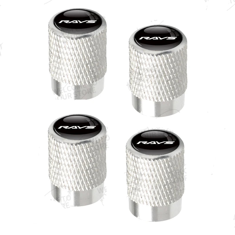 Four silver valve stem caps with black centers featuring 'RAVS' branding on a white background.