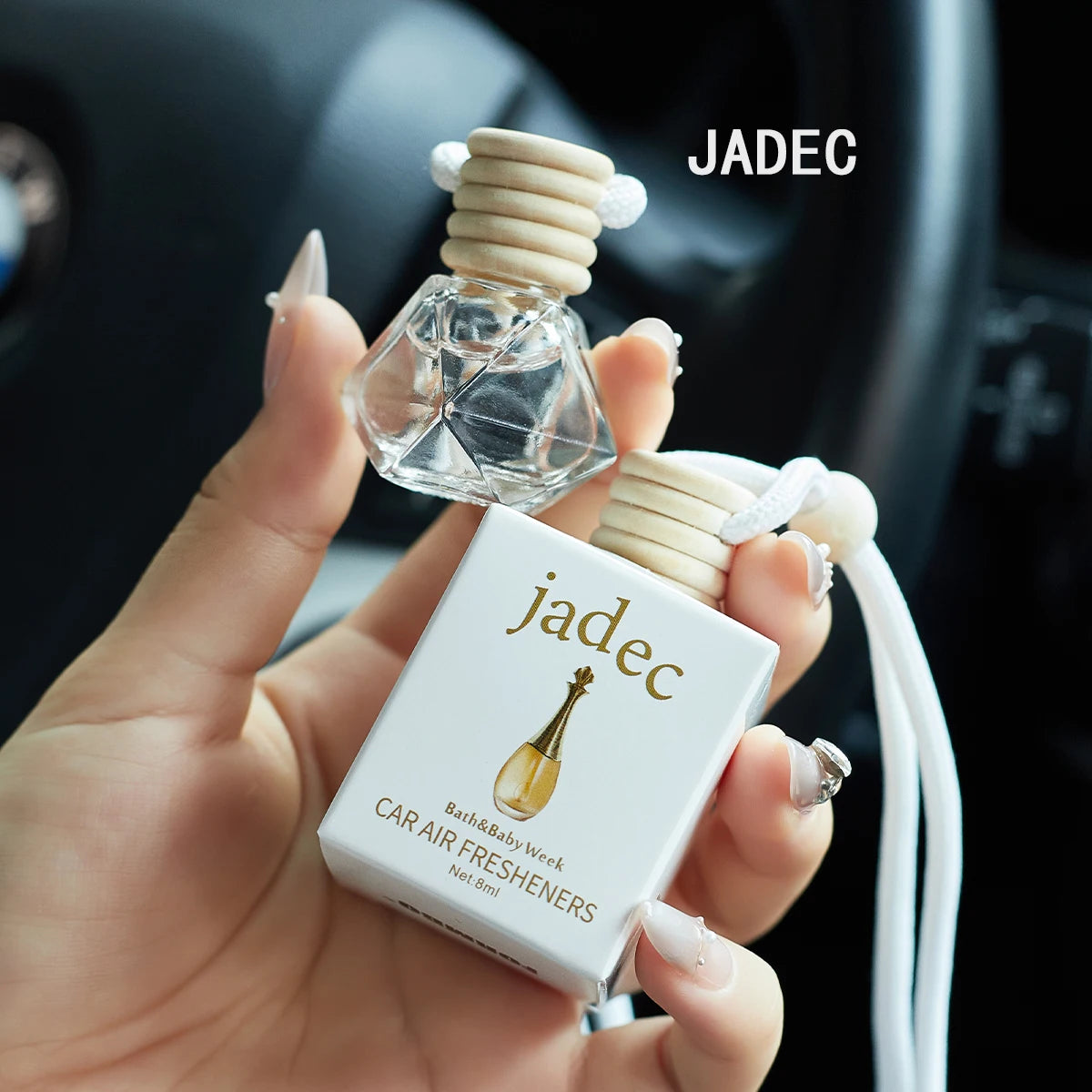 Car air freshener with packaging held by a hand, brand 'Jadec' visible