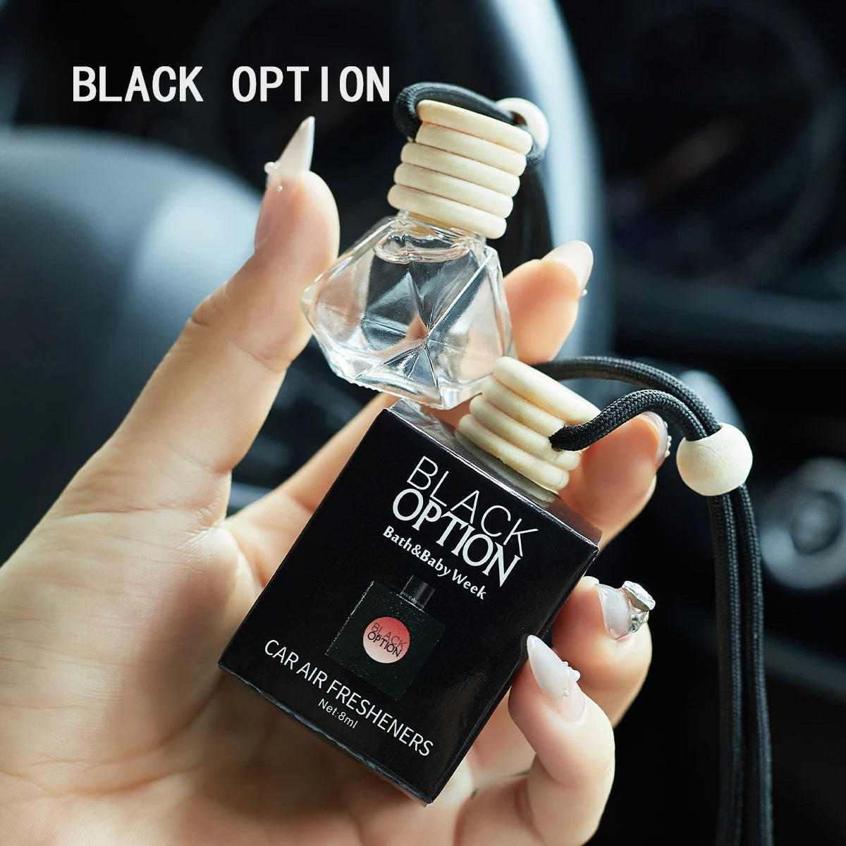 Car air freshener with packaging held by a hand, labeled 'Black Option'.